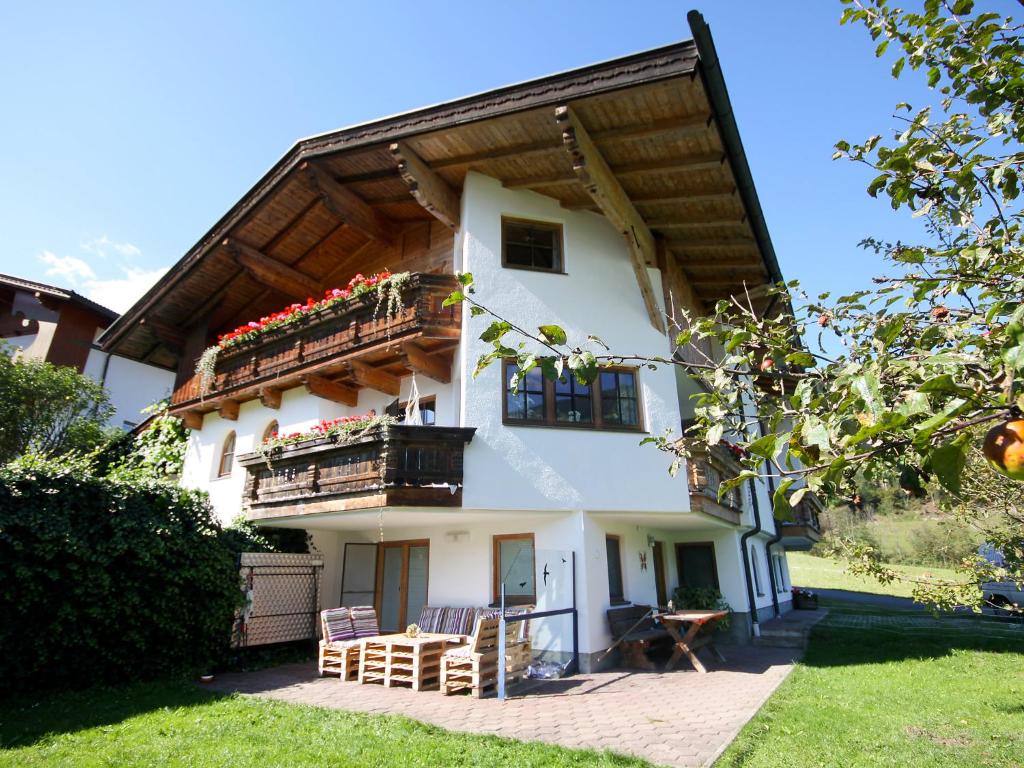 ein Haus mit 2 Balkonen sowie einem Tisch und Stühlen in der Unterkunft Apartment Hörhager by Interhome in Aschau