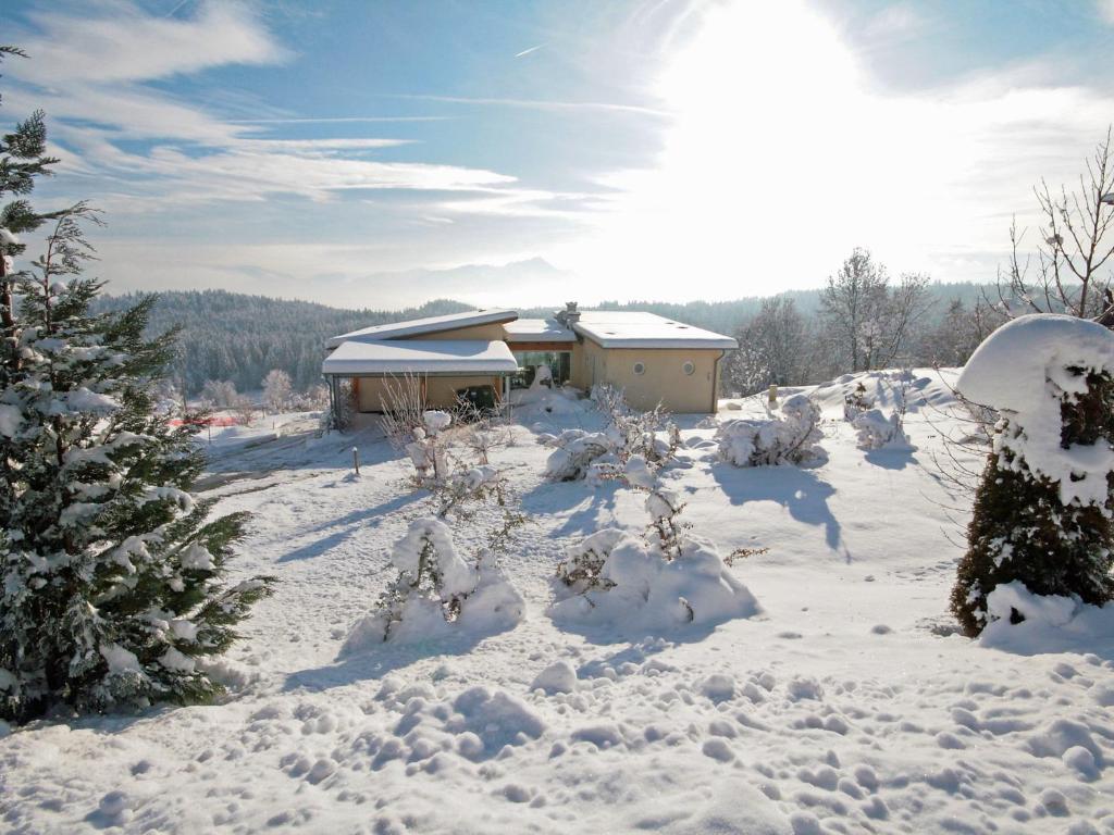 un patio cubierto de nieve con una casa en el fondo en Villa Carinthia by Interhome, en Köstenberg