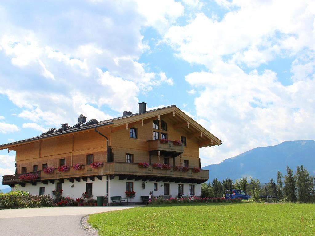 a large wooden building with flowers in front of it at Apartment Fürstauer by Interhome in Saalfelden am Steinernen Meer