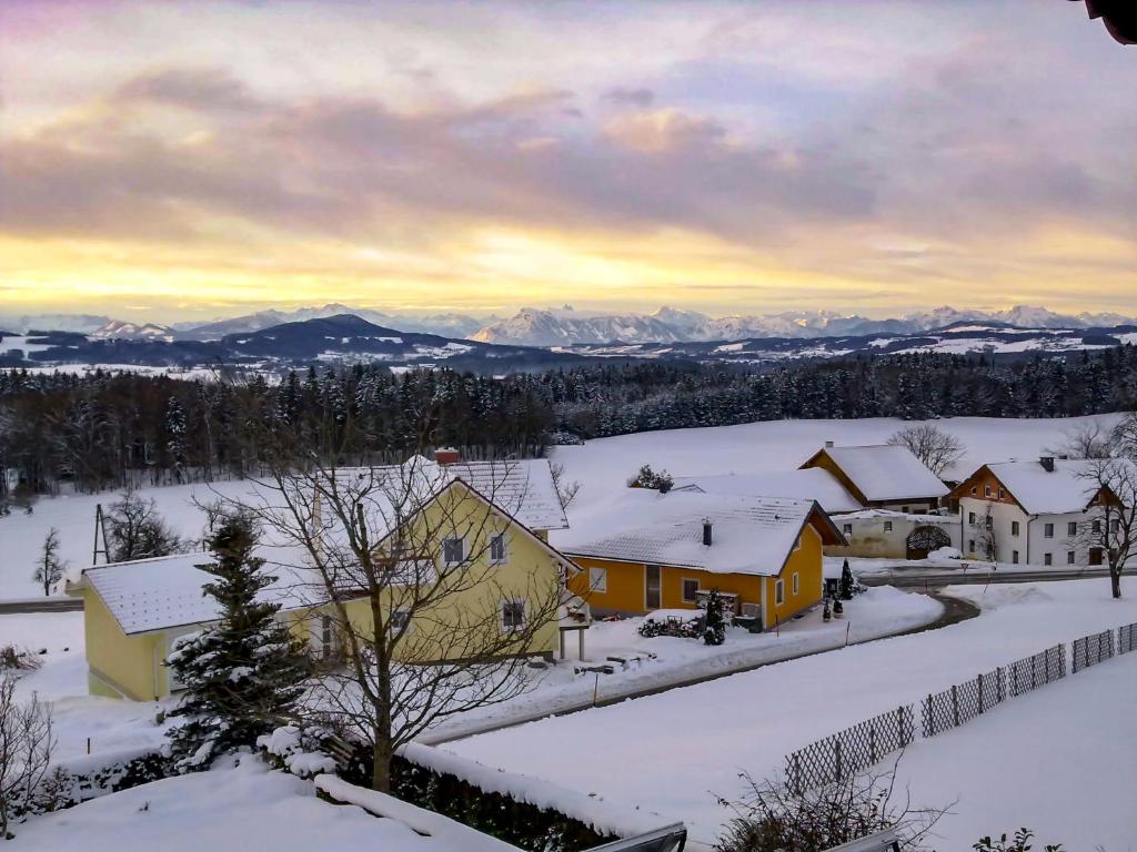 a village covered in snow with mountains in the background at Apartment Eisele by Interhome in Kirchberg bei Mattighofen