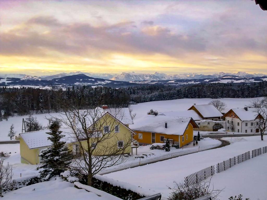 een dorp bedekt met sneeuw met bergen op de achtergrond bij Apartment Eisele by Interhome in Kirchberg bei Mattighofen