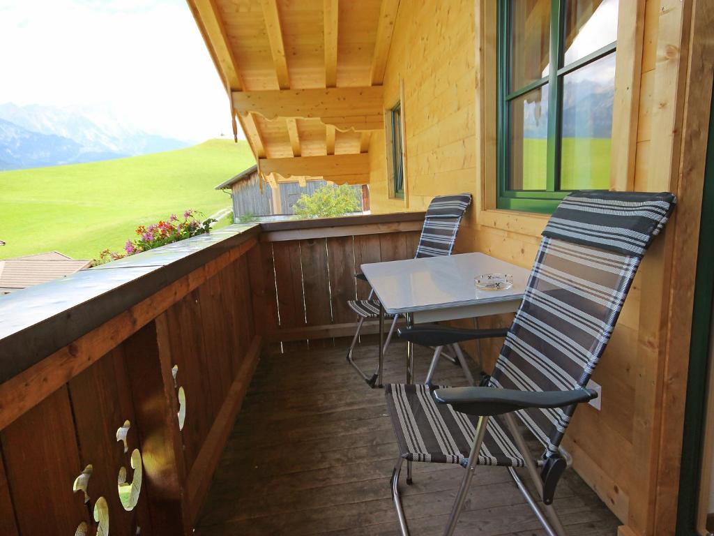 a porch with two chairs and a table on a deck at Apartment Steinernes Meer by Interhome in Saalfelden am Steinernen Meer