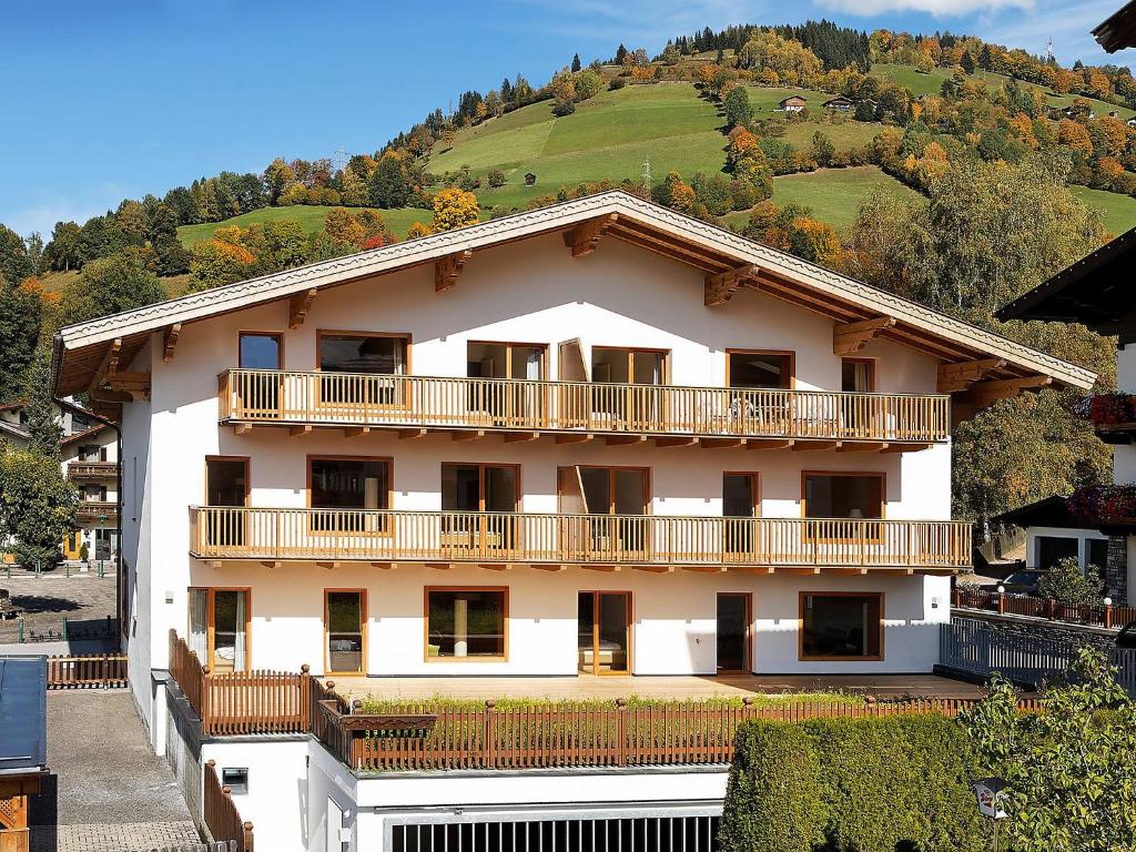 um edifício branco com uma varanda e uma colina em Apartment Haus Sonne by Interhome em Erlberg