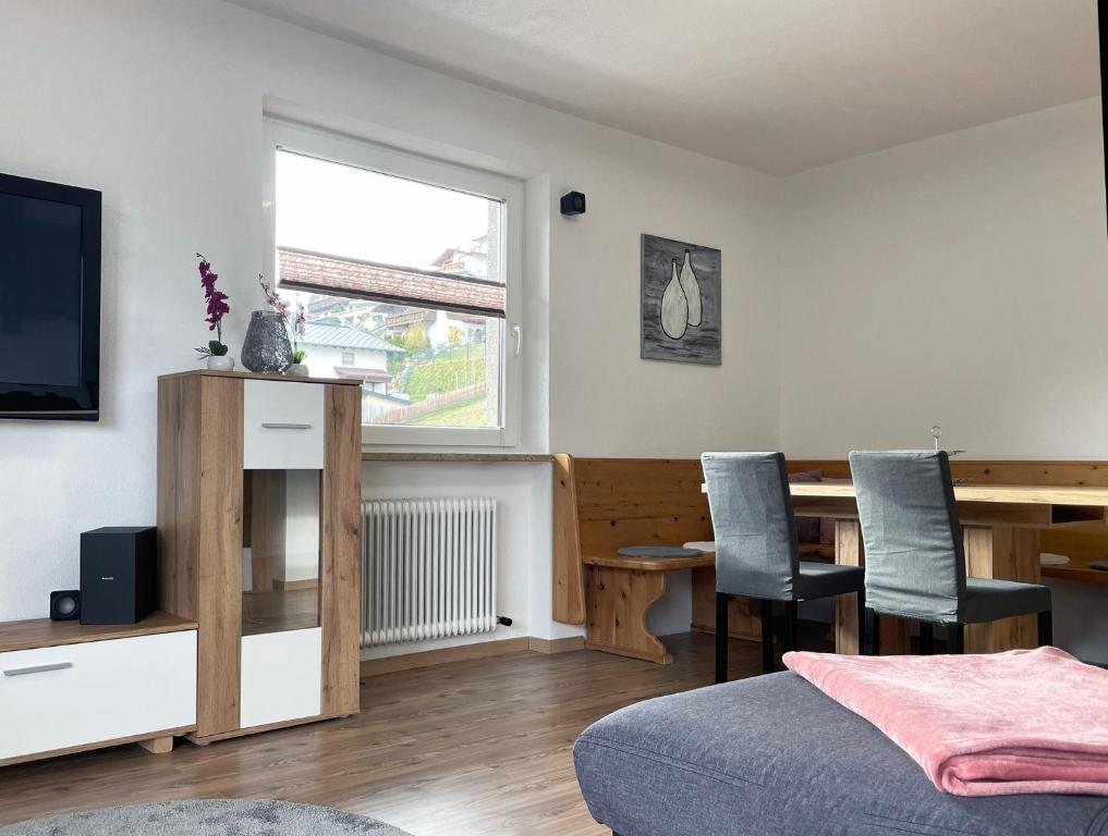 sypialnia z biurkiem i stołem z krzesłami w obiekcie Ferienwohnung Sunhill w mieście Sellrain