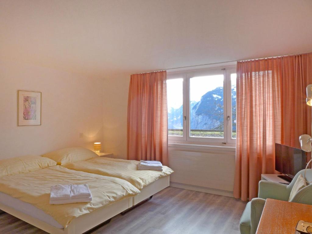 1 dormitorio con cama y ventana grande en Apartment Helene Apt- Hella by Interhome, en Wengen