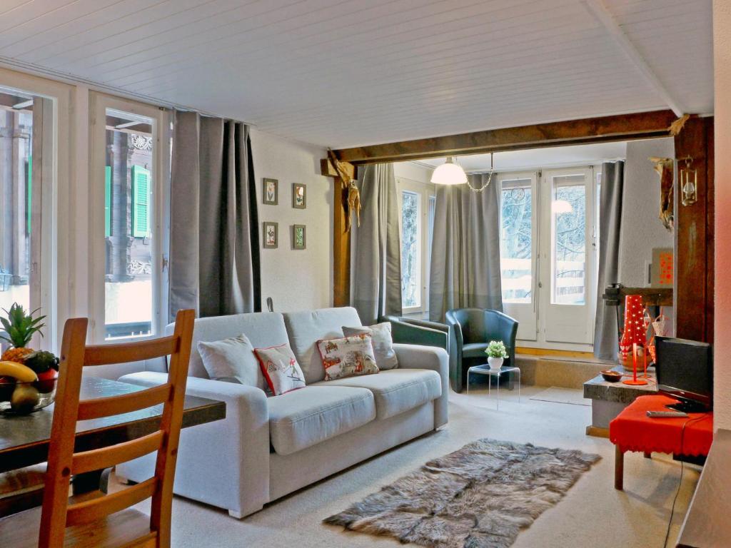 un soggiorno con divano bianco e alcune finestre di Apartment Schweizerhof-1 by Interhome a Wengen