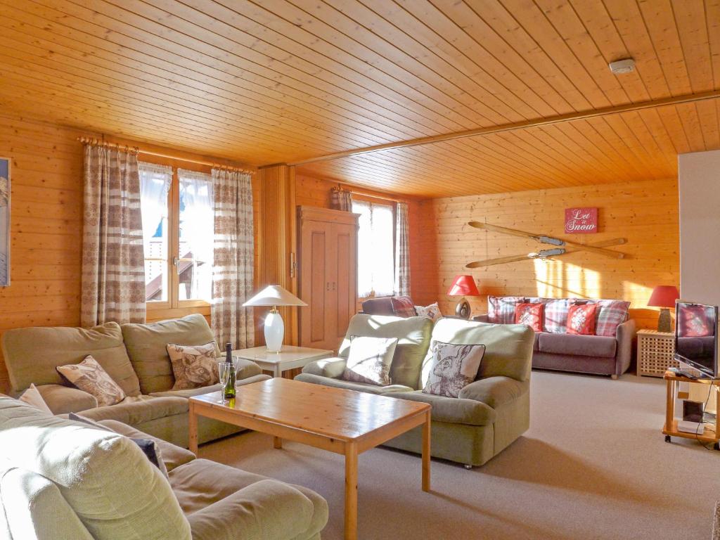 - un salon avec des canapés et un plafond en bois dans l'établissement Apartment Chäs Gruebi by Interhome, à Wengen