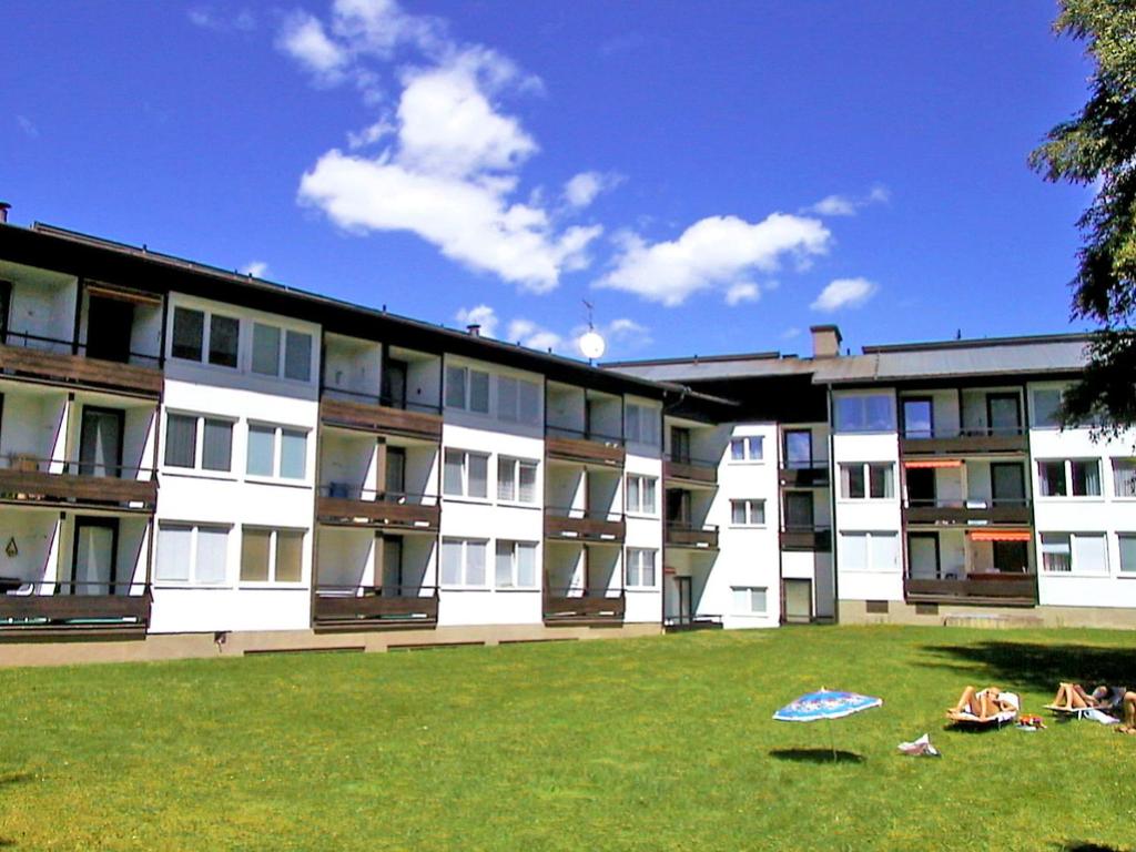 un grupo de personas yaciendo en la hierba frente a un edificio en Apartment Alpenland-14 by Interhome, en Seefeld in Tirol