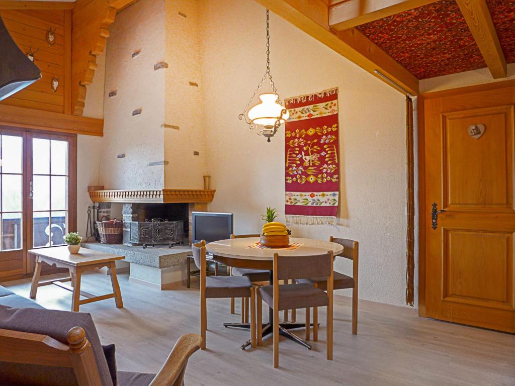 a living room with a table and a fireplace at Apartment Bergkristall by Interhome in Wengen
