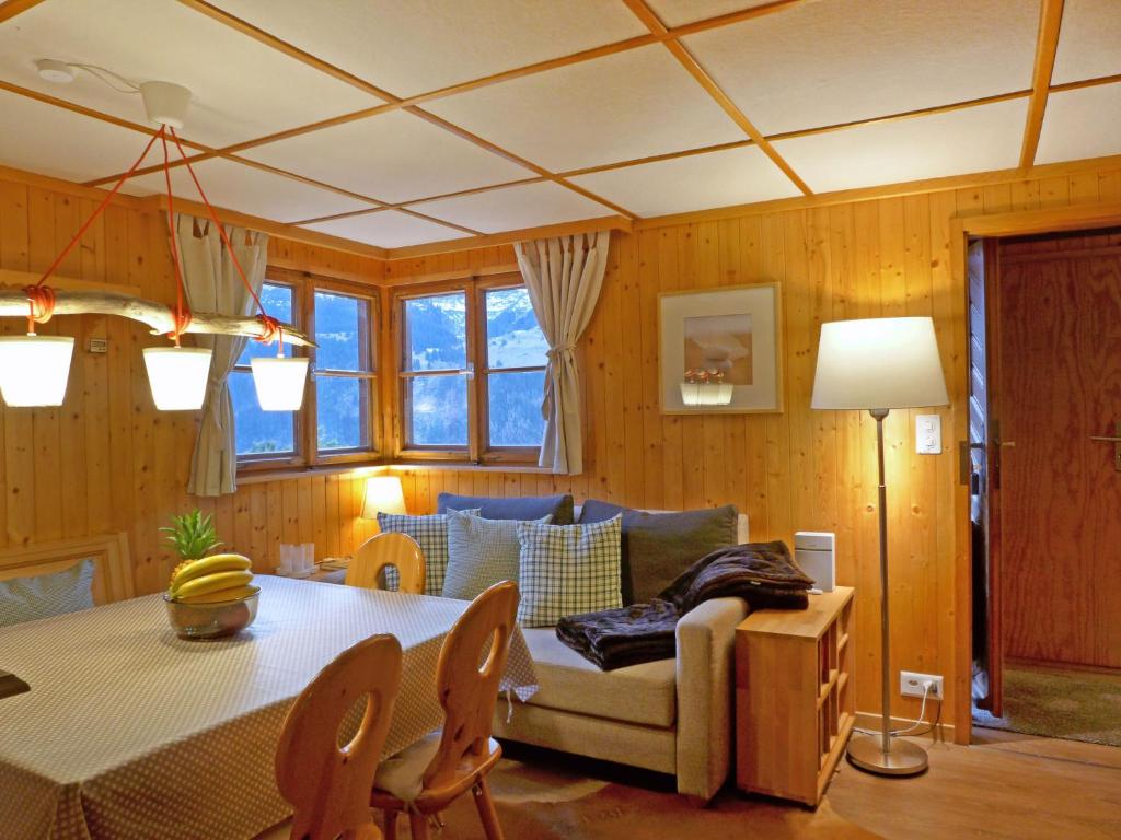 a living room with a table and a couch at Chalet Zwärgli by Interhome in Wengen