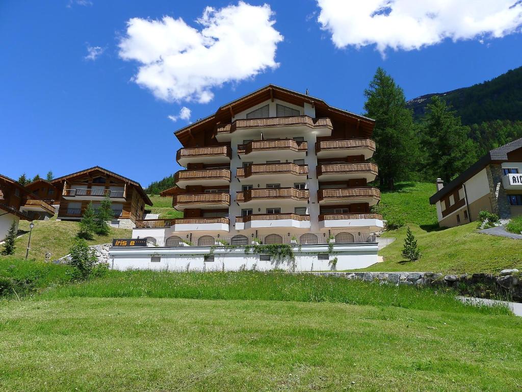 a large building on a hill with a green field at Apartment Iris B-5 by Interhome in Leukerbad