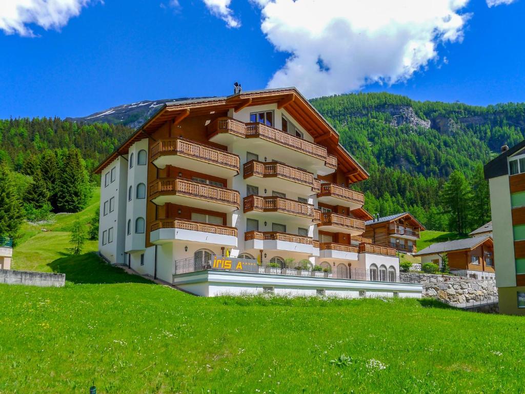 a large apartment building on a hill with a green field at Apartment Iris A-2 by Interhome in Leukerbad