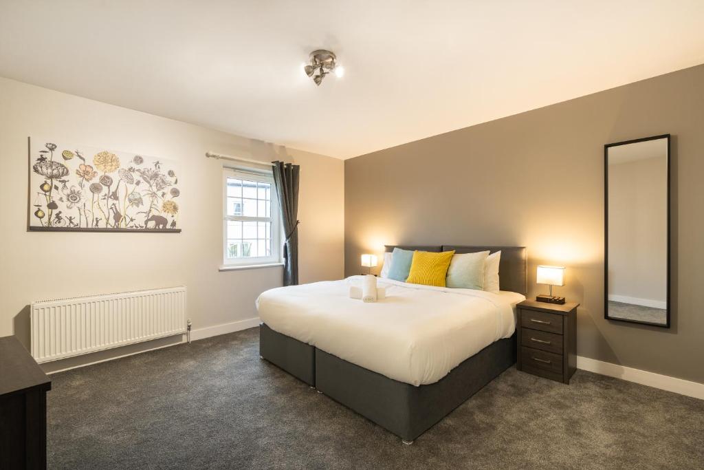 1 dormitorio con 1 cama grande y espejo en Escape Ordinary at Devenish Manor en Enniskillen