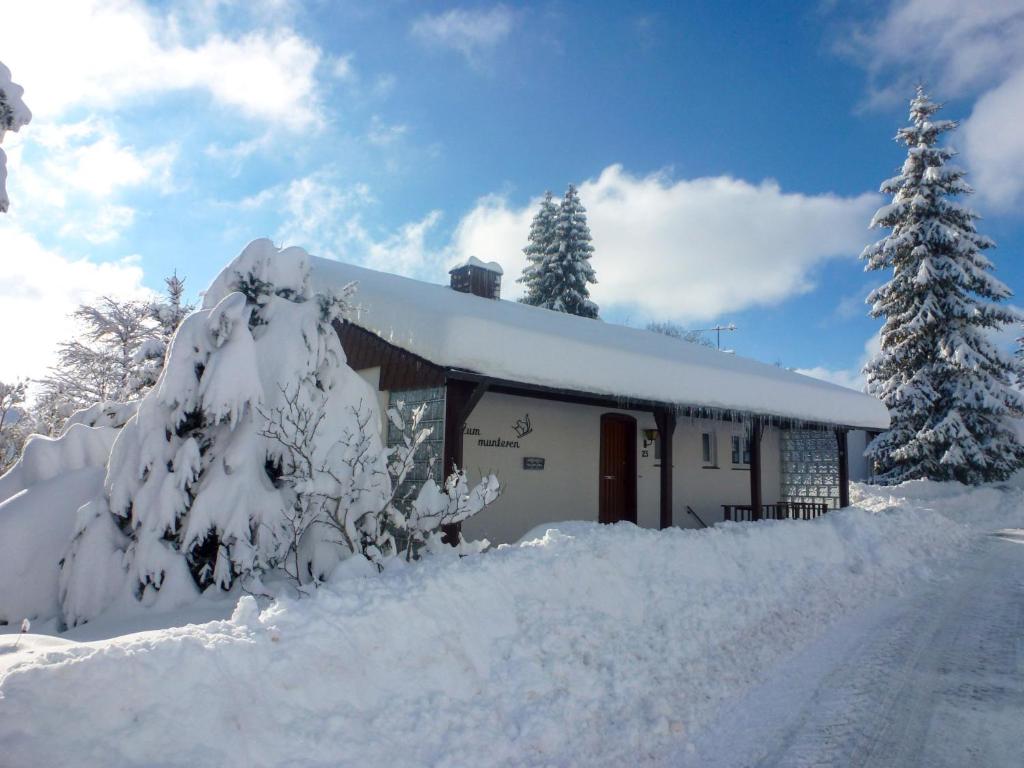 a house covered in snow next to a road at Holiday Home Zum munteren Eichhörnchen by Interhome in Dittishausen