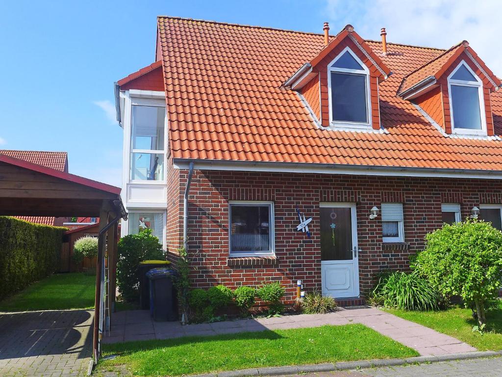 ein Backsteinhaus mit orangefarbenem Dach in der Unterkunft Holiday Home Aquantis by Interhome in Norddeich