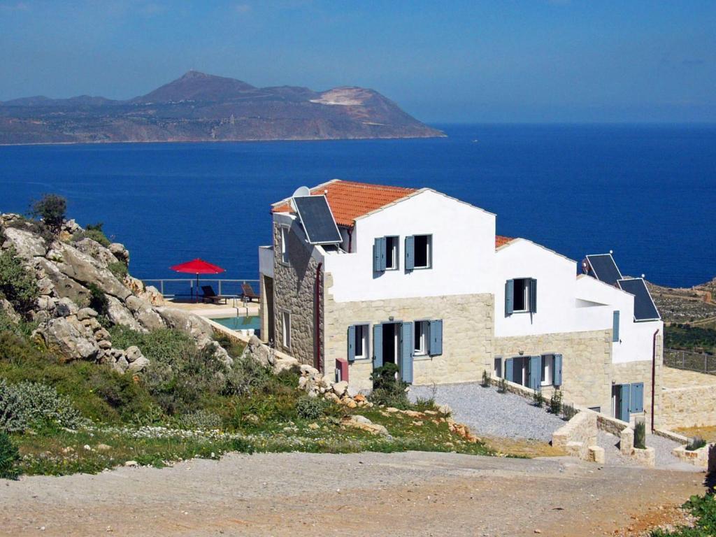 a house on a hill with the ocean in the background at Holiday Home Puntiti 3 by Interhome in Kókkinon Khoríon