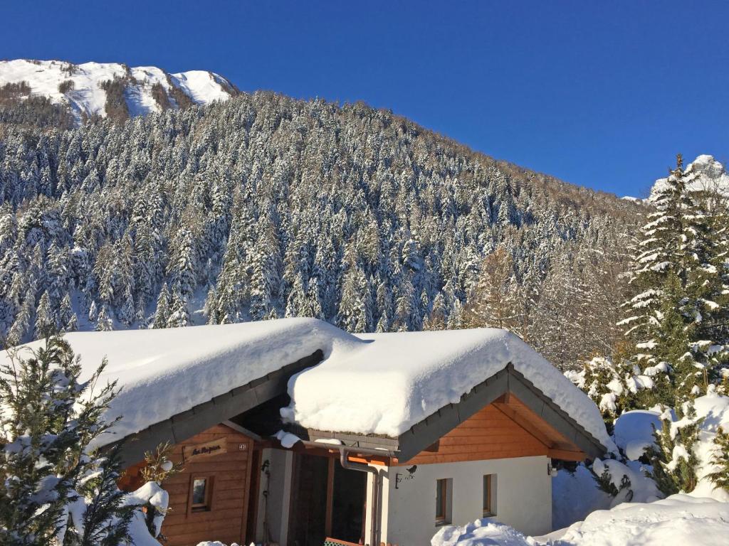 een huis bedekt met sneeuw voor een berg bij Chalet Ropiar by Interhome in Ovronnaz
