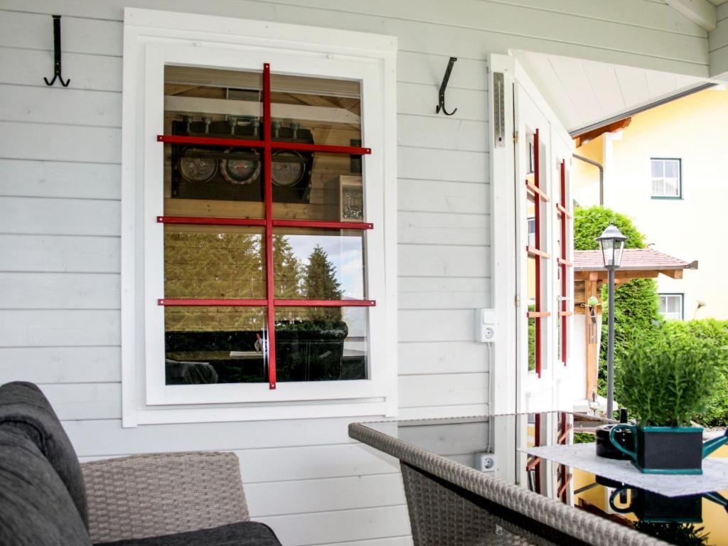 a screened porch with a red window on a house at Apartment Poldi by Interhome in Haus im Ennstal