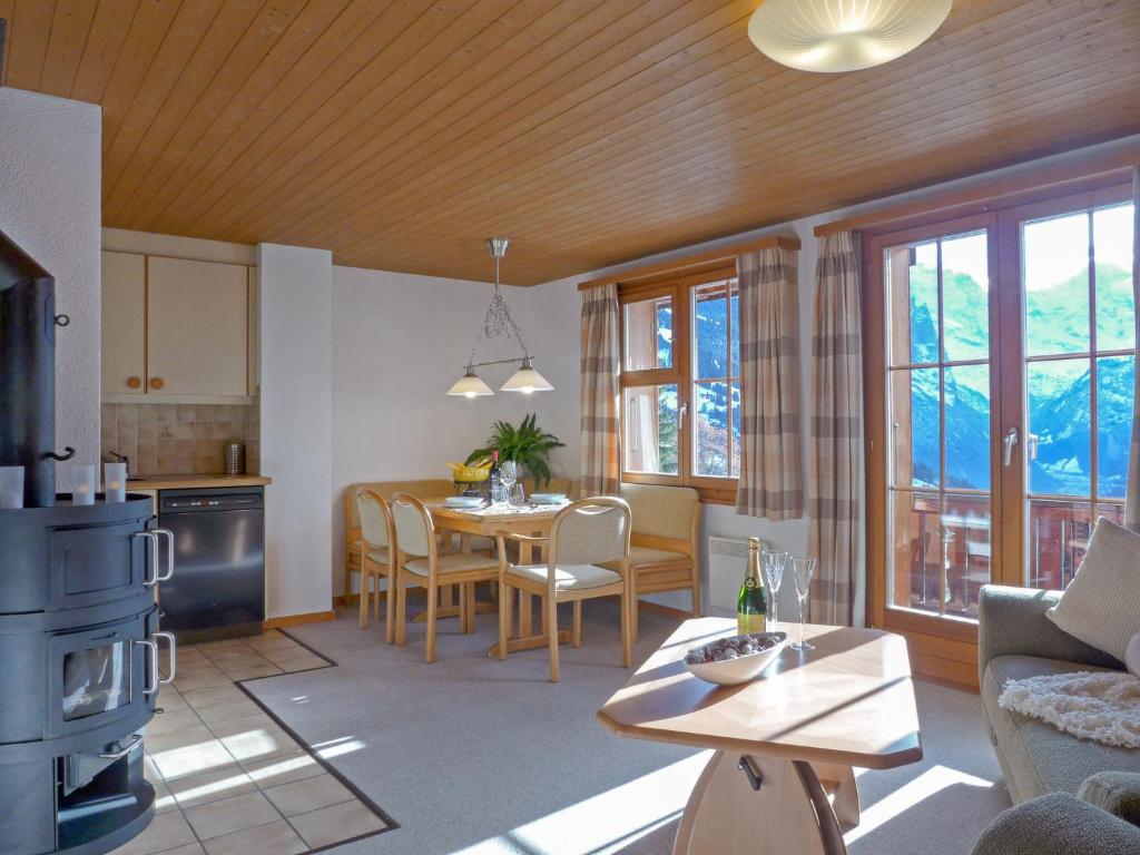 a kitchen and living room with a table and chairs at Apartment Bluemewäg Apt-R by Interhome in Wengen