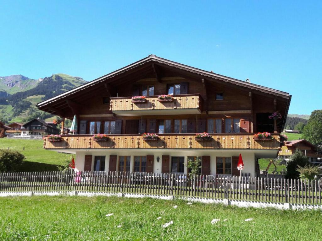 uma casa grande com uma cerca em frente em Apartment Lohnerhus-2 by Interhome em Grindelwald