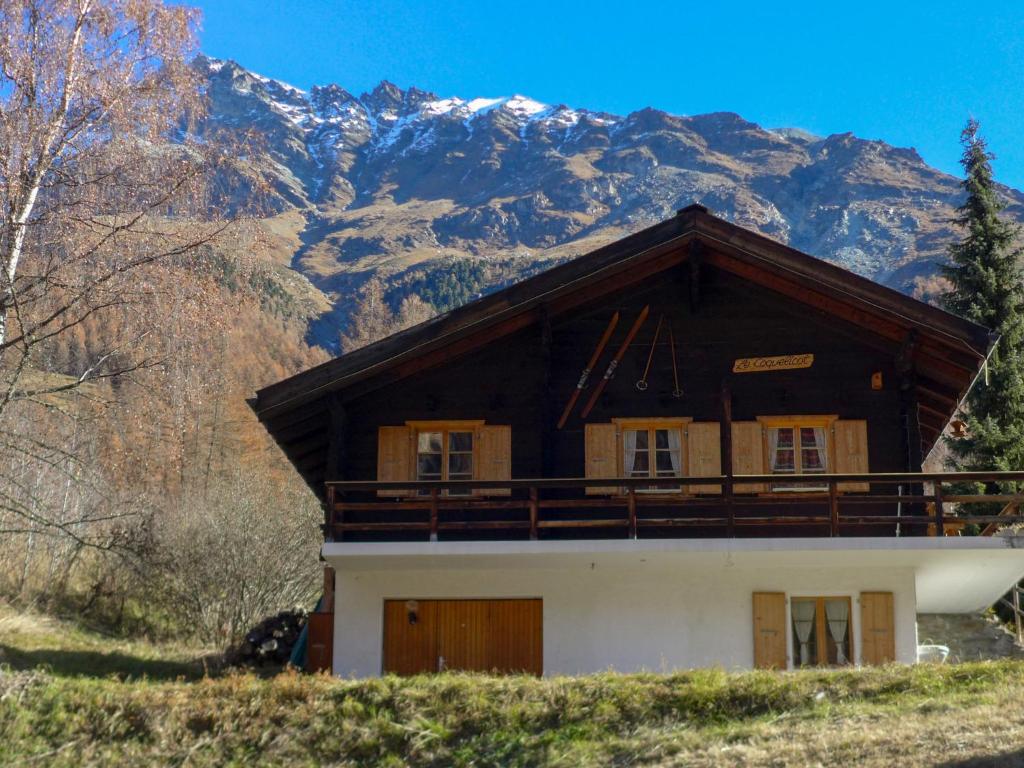 a house on a hill with mountains in the background at Chalet Coquelicot by Interhome in Zinal