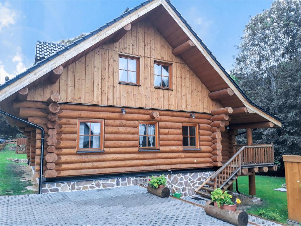 una cabaña de madera con una escalera delante de ella en Chalet Lazny by Interhome en Pohorsko