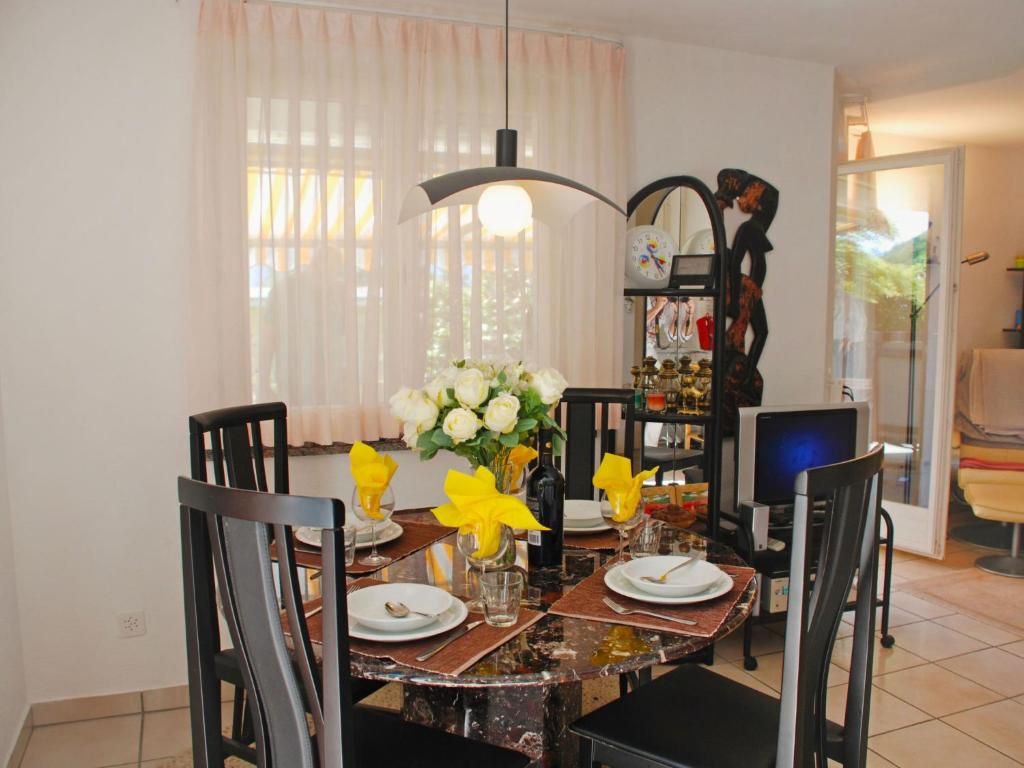 a dining room with a table with chairs and a tableablish at Apartment Giardinetto by Interhome in San Nazzaro