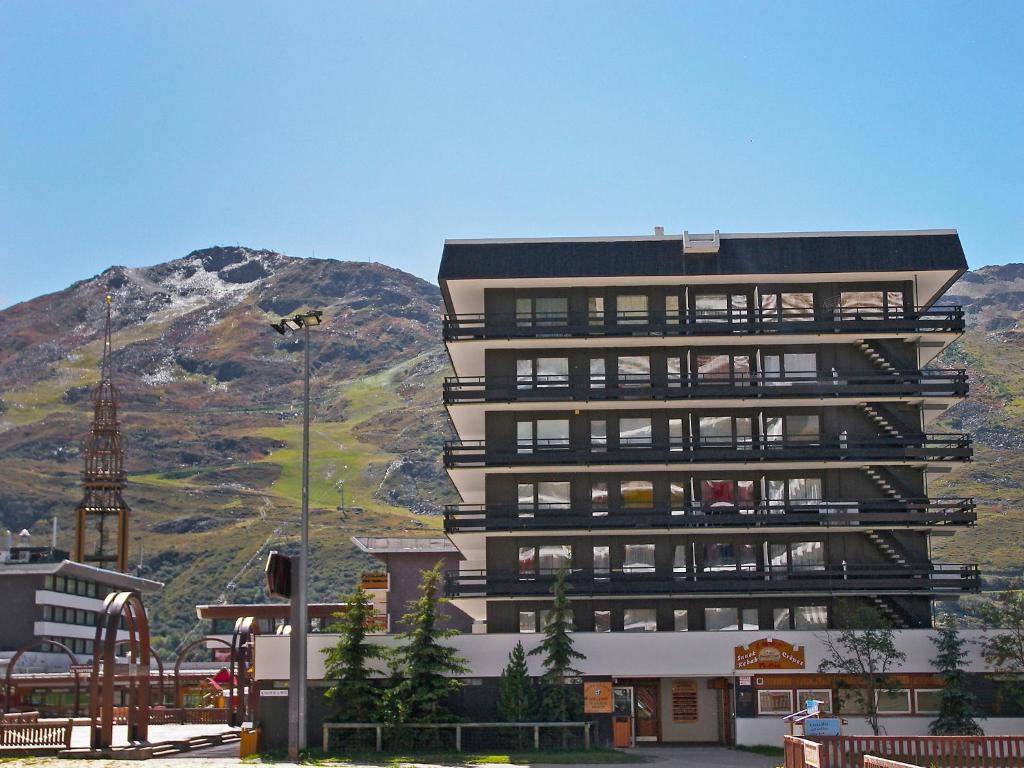 a tall building in front of a mountain at Apartment Oisans 37 by Interhome in Les Menuires