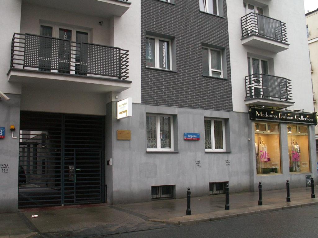 a building with a black door and a store at Na Wspólnej Apartament in Warsaw
