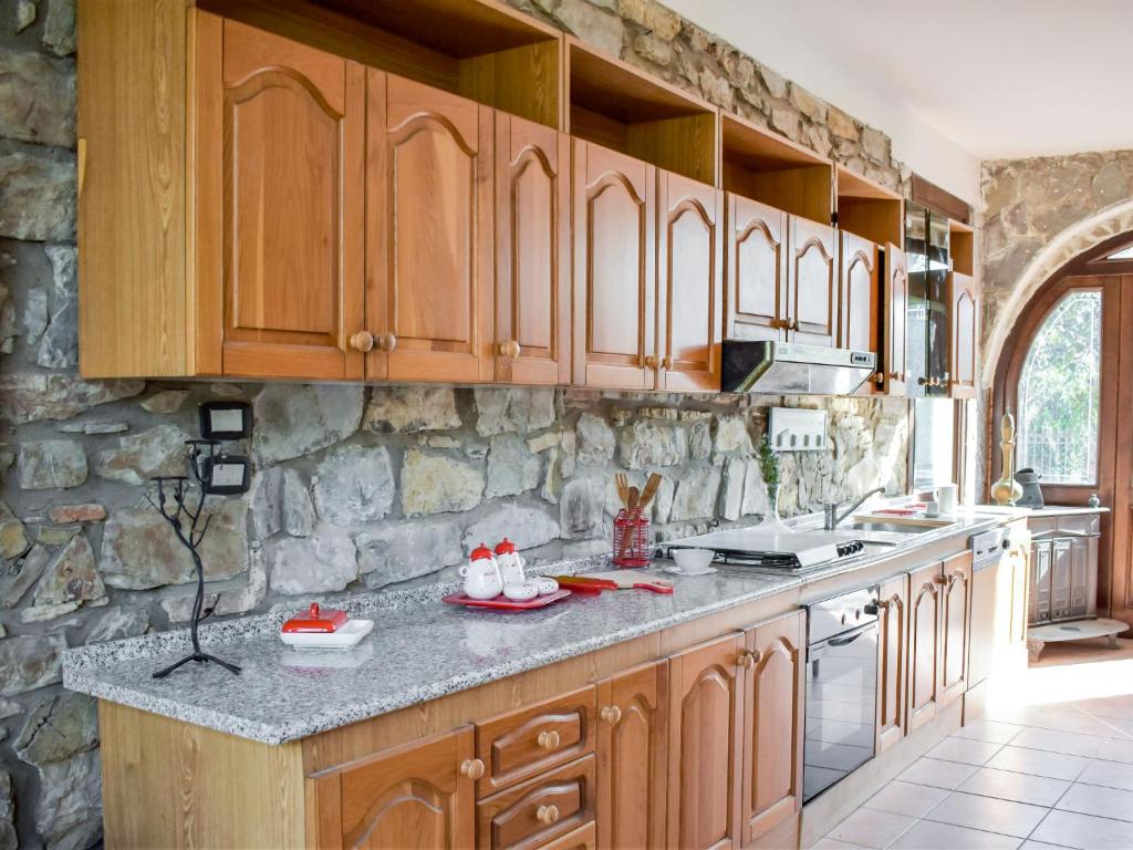 kuchnia z drewnianymi szafkami i kamienną ścianą w obiekcie Villa Tenuta Valente by Interhome w mieście Giungano