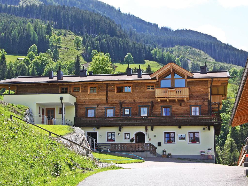 ein großes Holzhaus auf einem Berg in der Unterkunft Apartment Mooslehen-1 by Interhome in Schattberg