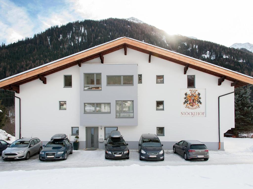 a white building with cars parked in front of it at Apartment Stöcklhof-1 by Interhome in Pettneu am Arlberg
