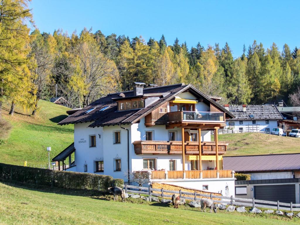 una casa su una collina con mucche in un campo di Apartment Renauer by Interhome a Mösern