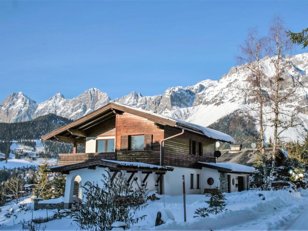 a house in the snow with mountains in the background at Holiday Home Berghaus Weitblick by Interhome in Ramsau am Dachstein