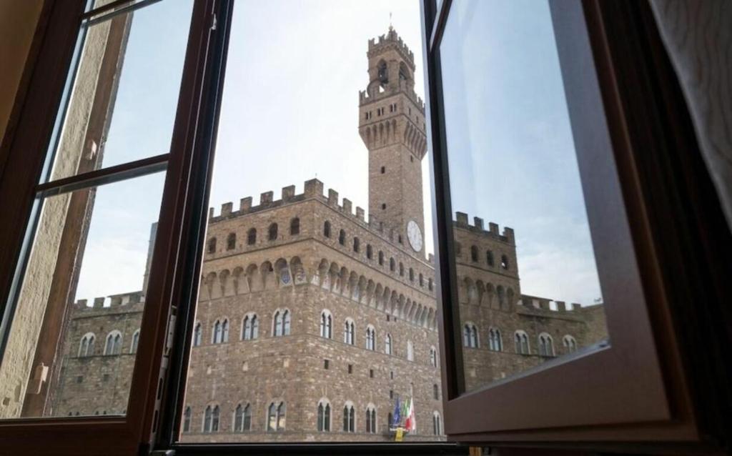 a window view of a large building with a clock tower at Signoria Vista in Florence