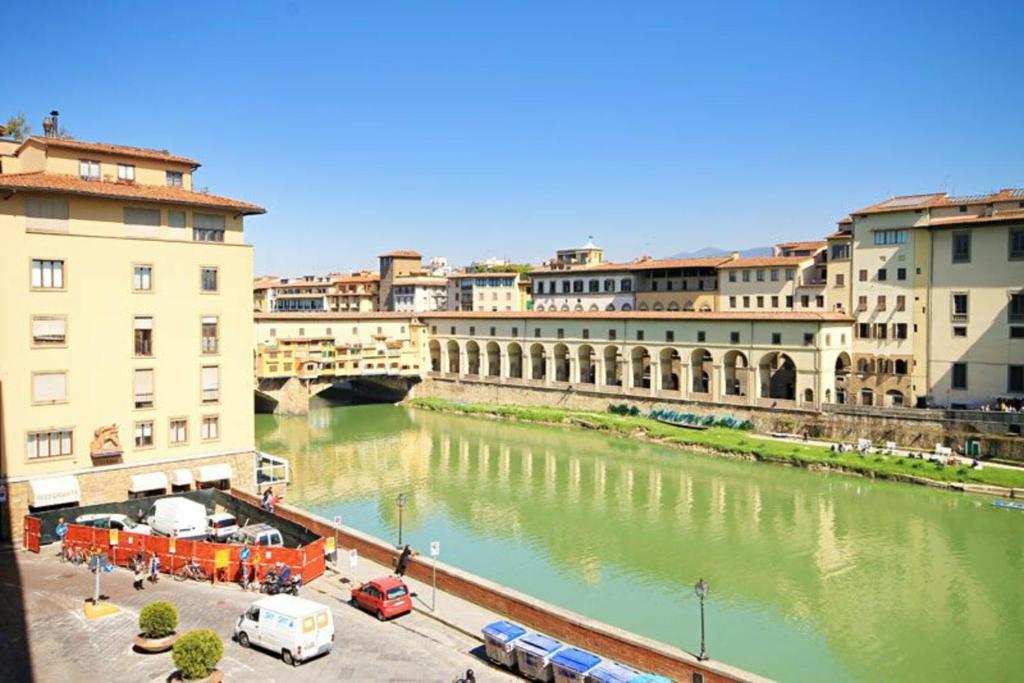 a view of a river with buildings and a bridge at Canottieri in Florence