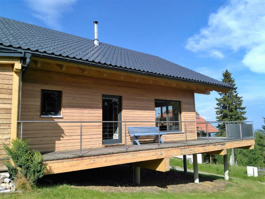 a log cabin with a deck and a bench at Chalet Dolzer by Interhome in Hochrindl