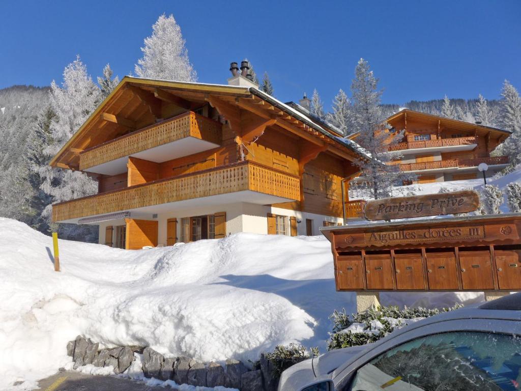 a building in the snow with a car in front of it at Apartment Aiguilles Dorées III-2 by Interhome in Villars-sur-Ollon