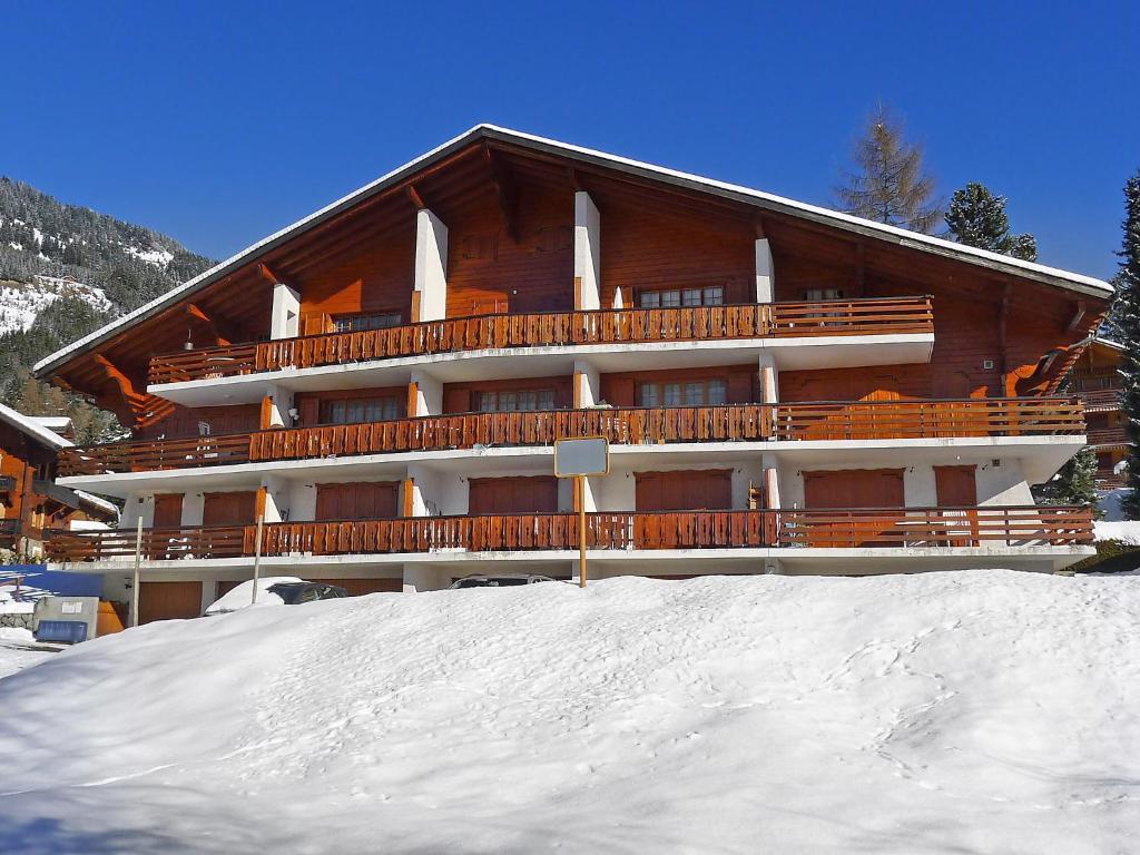 a large building with snow in front of it at Apartment Ermitage 11 by Interhome in Villars-sur-Ollon