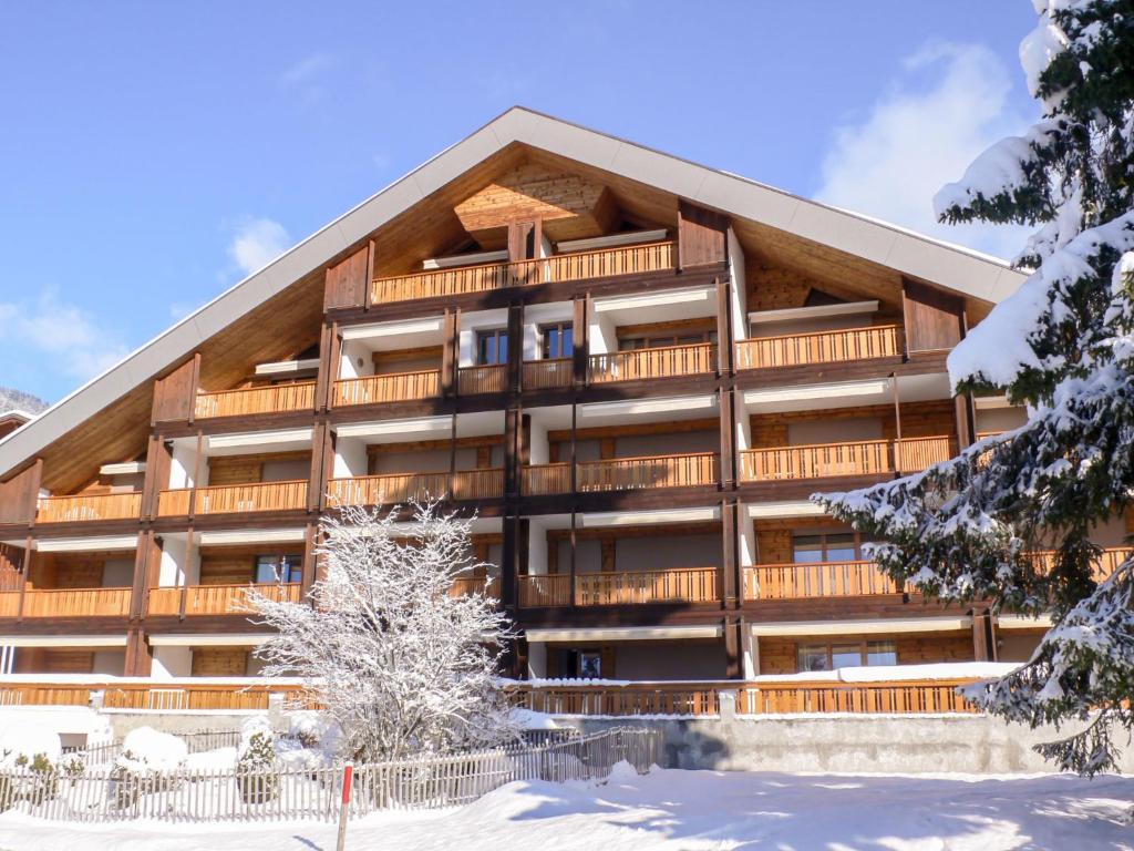 a large building with snow in front of it at Studio La Bercière 7 by Interhome in Villars-sur-Ollon