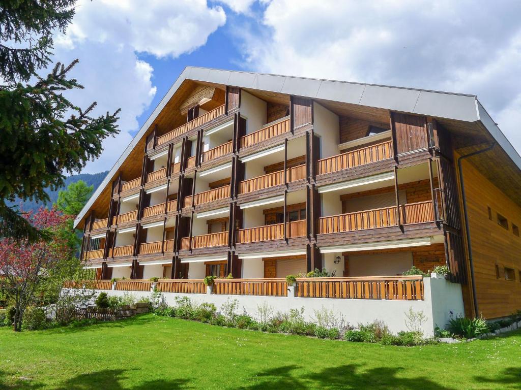 a large apartment building with a lawn in front of it at Studio La Bercière 7 by Interhome in Villars-sur-Ollon