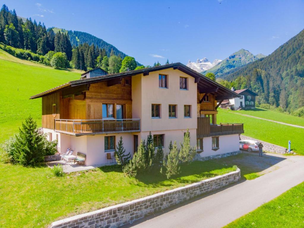 ein Haus auf einem Hügel mit einem grünen Feld in der Unterkunft Apartment Ainhauser-1 by Interhome in Rodund