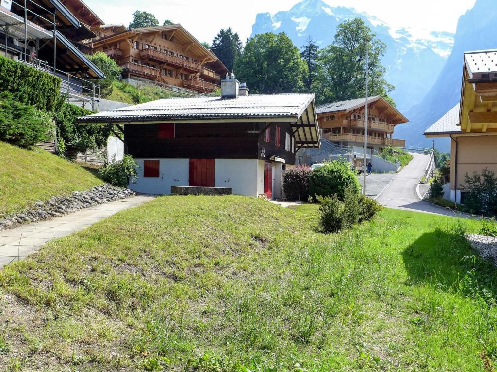 ein kleines Haus auf einem Hügel mit Bergen im Hintergrund in der Unterkunft Apartment Chalet Unterpfand 10 by Interhome in Grindelwald