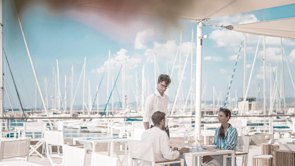 a group of people sitting at tables on a yacht at Marina di Scarlino Resort in Puntone di Scarlino