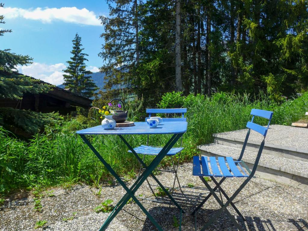ヴェルビエにあるApartment Djabo by Interhomeの庭に青いテーブルと青い椅子2脚