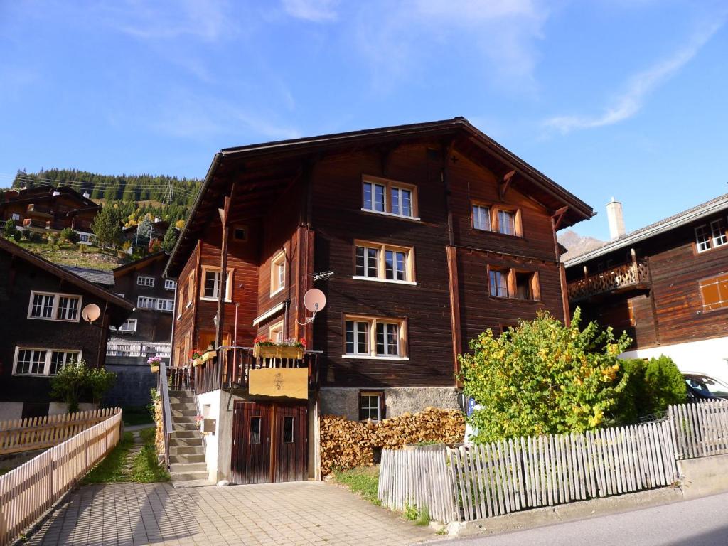 a wooden house with a fence in front of it at Apartment Crestatgiet by Interhome in Rueras