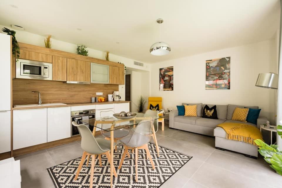 a kitchen and living room with a table and a couch at Stylish New 1 bedroom apartment in juan les pins in Antibes