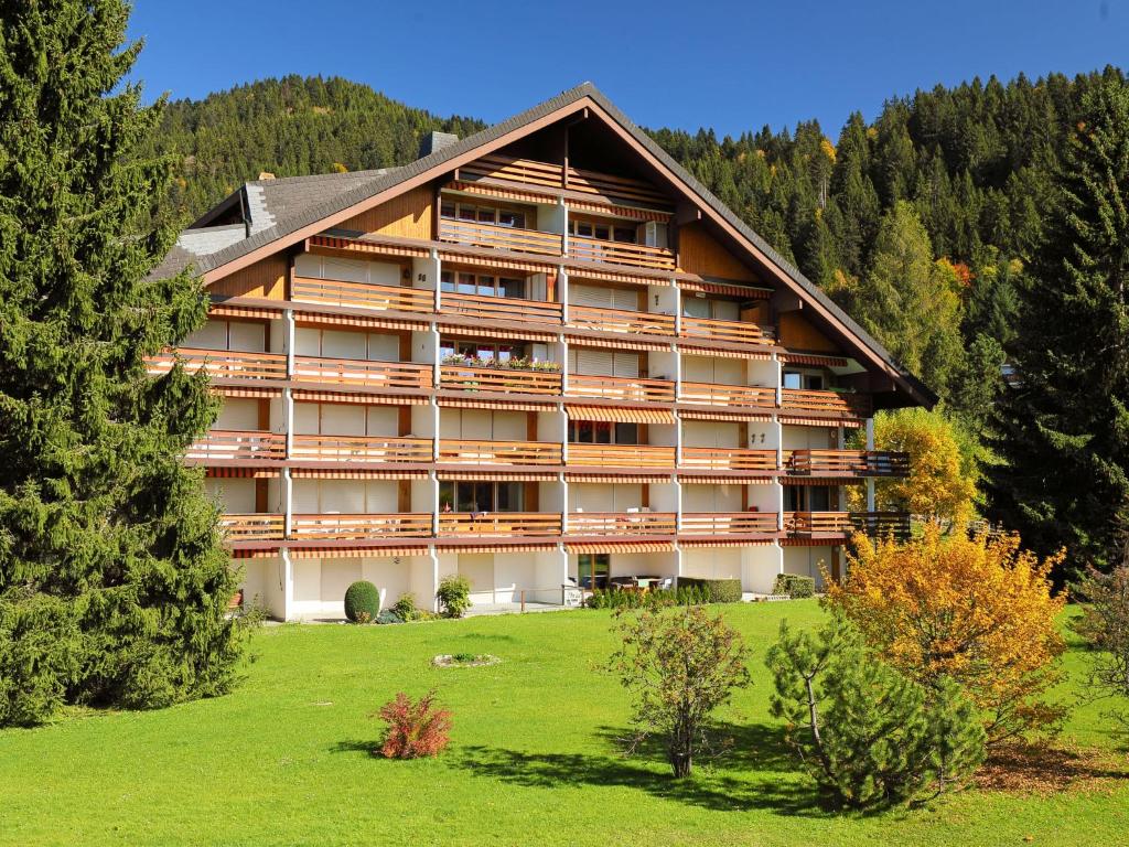 a large resort building with a green field and trees at Apartment Diamant 6 by Interhome in Villars-sur-Ollon