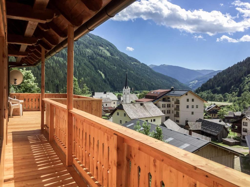 a wooden balcony with a view of a town at Chalet Felsenhütte by Interhome in Ebene Reichenau