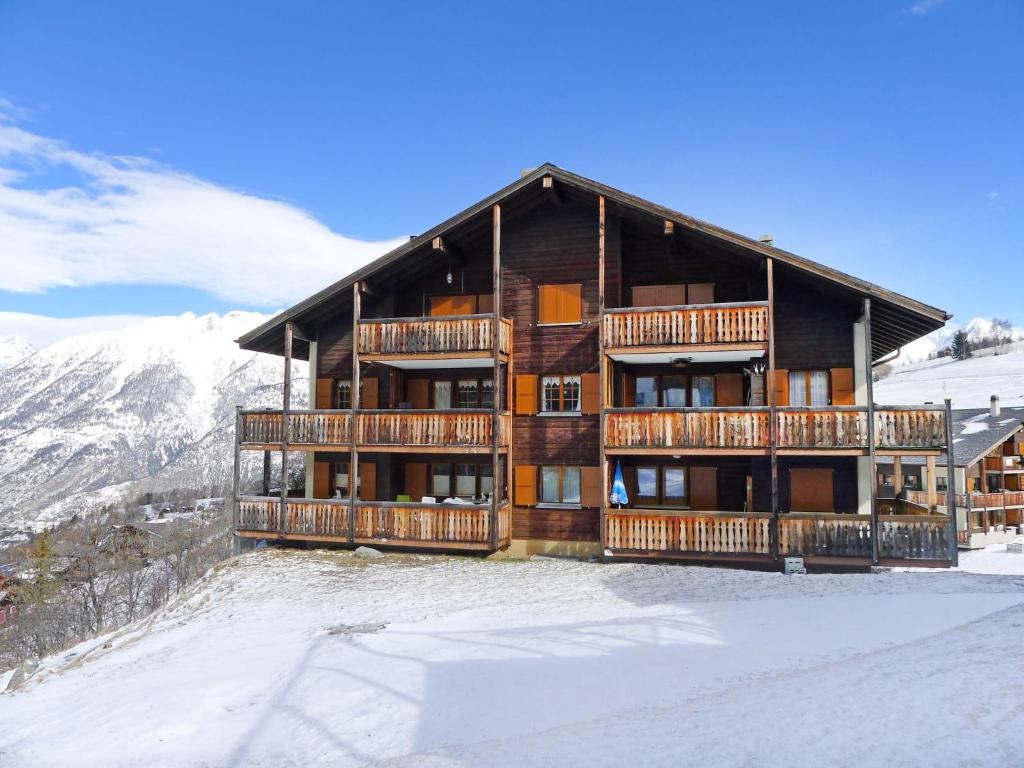 a large wooden building with balconies on a mountain at Apartment Saskia by Interhome in Bürchen